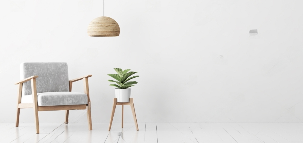 pared blanca con silla de madera, luz y planta